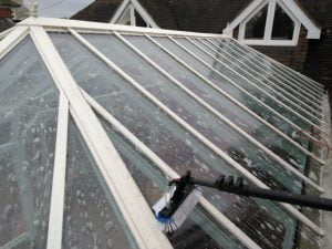 Cleaning a conservatory roof with industrial detergent and specialized equipment