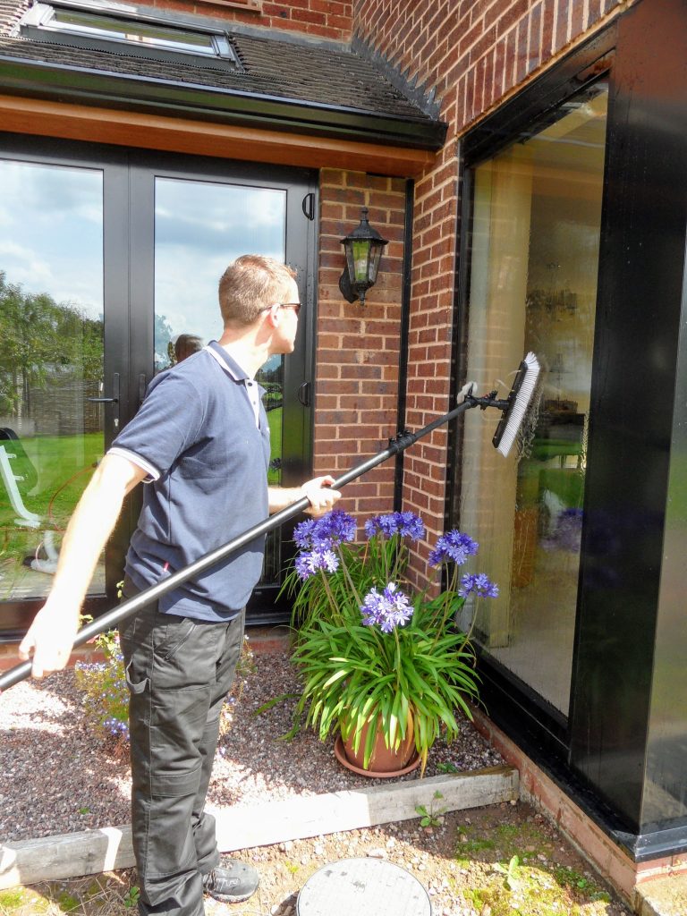 Cleaning large windows with water fed pole